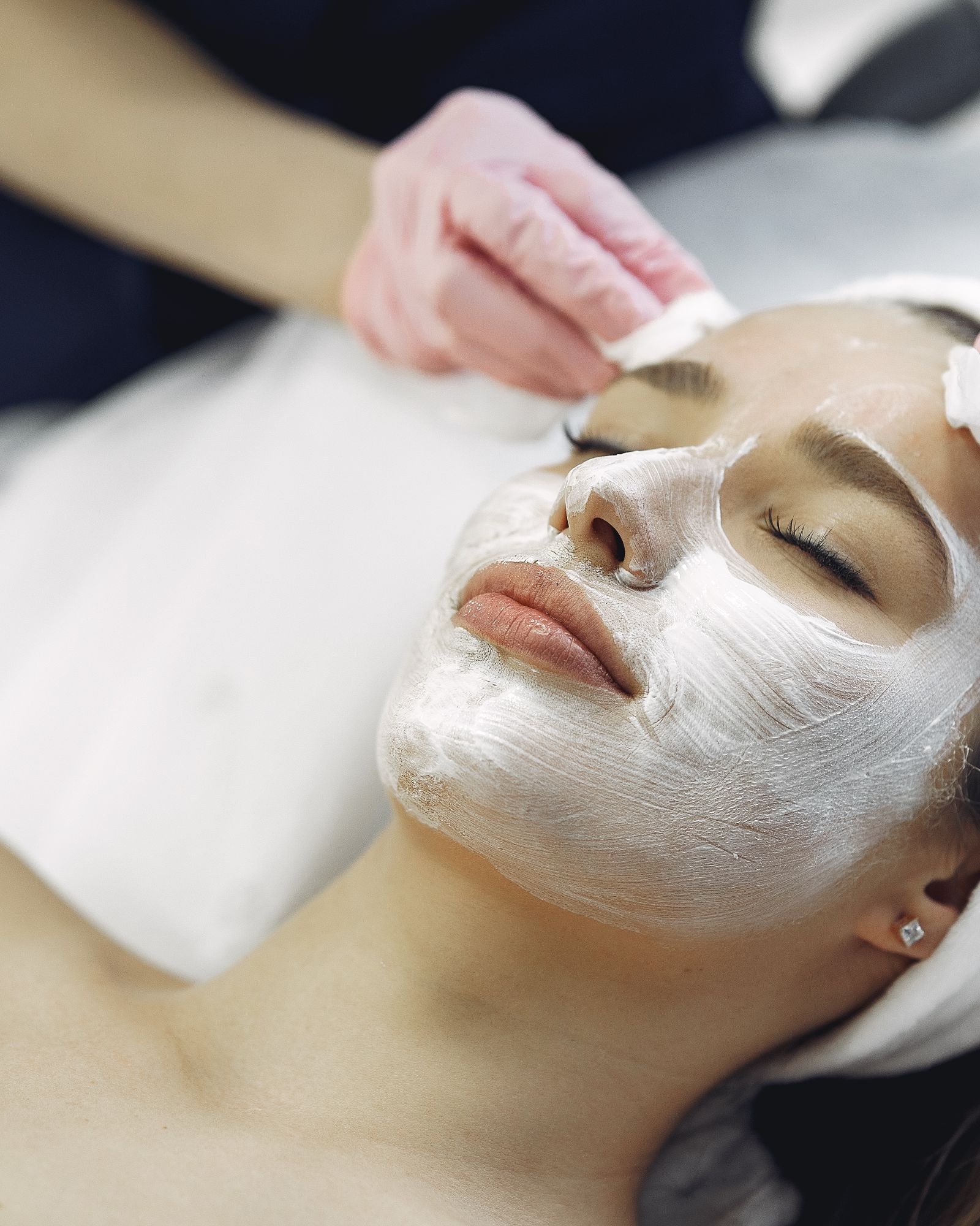 A woman receiving a calming facial treatment at a skin clinic